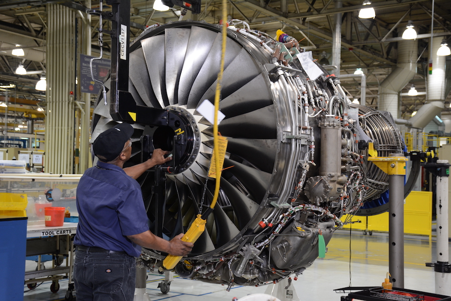 A mechanic services a Pratt and Whitney engine.