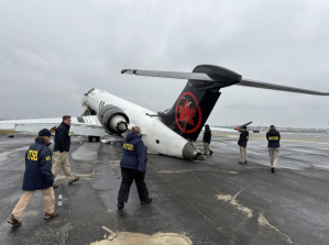 NTSB investigators walk the scene of the March 22 collision between an Air Canada Express plane and a firefighting vehicle on Runway 4 at LaGuardia Airport.